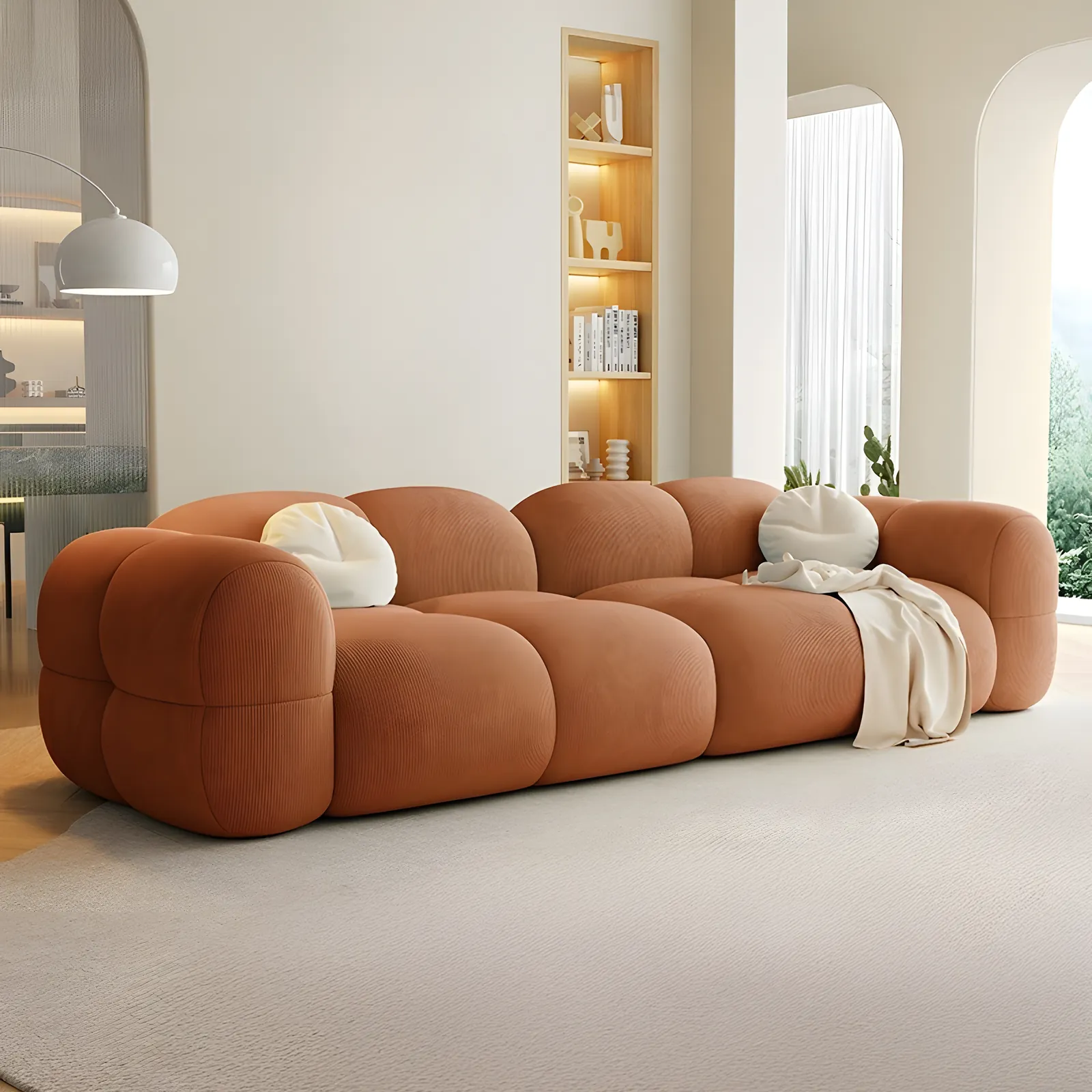 A terracotta Kristalia sofa in a bright room with arched alcoves